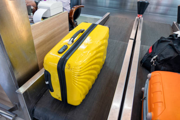 Yellow large luggage on belt at counter airline Yellow large luggage on belt at counter check-in airline yellow belt stock pictures, royalty-free photos & images
