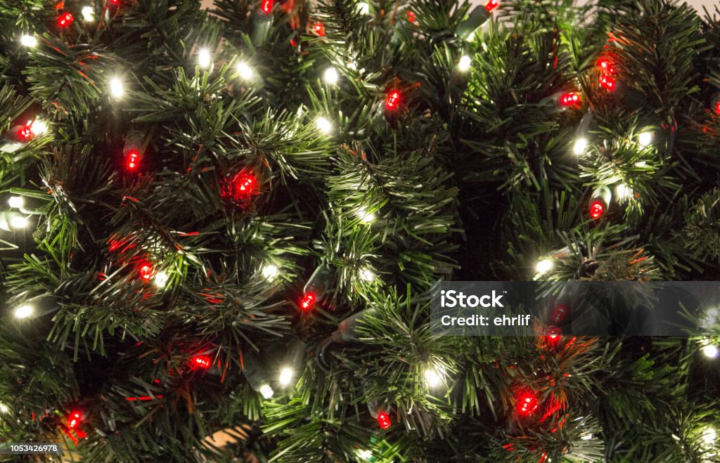 Multi Colored Illuminated Lights On Christmas Tree Green Christmas tree with multi colored lights in horizontal orientation with copy space. Christmas Tree Stock Photo