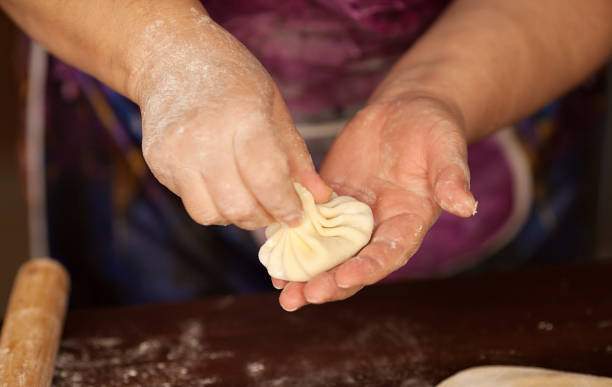 istock Khinkali, dumplings, meat in the dough cooking with hands. 1053429262