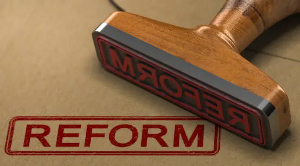 3D illustration of a rubber stamp with the word reform stamped on kraft paper envelope.