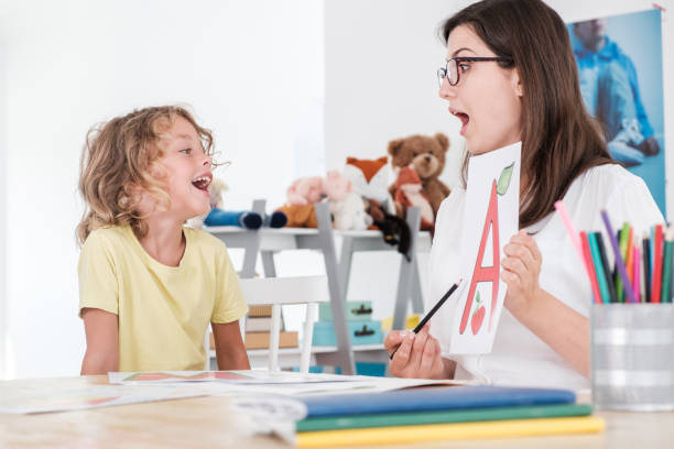 istock A happy child pronouncing a letter during speech therapy with a specialist. 1053433056