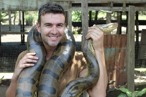 Man with a giant Anaconda around his neck.