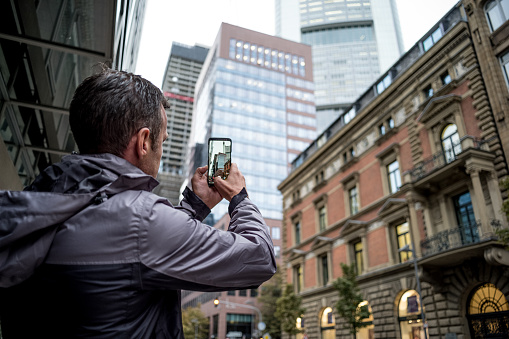 Man taking photos with mobile phone in the german city