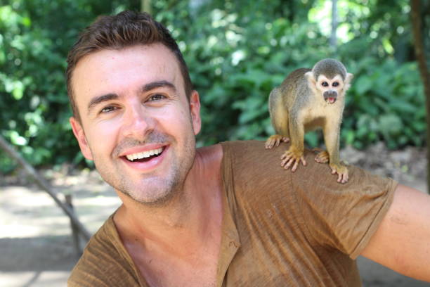 istock Handsome man with titi monkey on his shoulder 1053436834