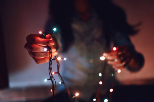 istock Midsection of girl holding string lights in her hand 1053440992