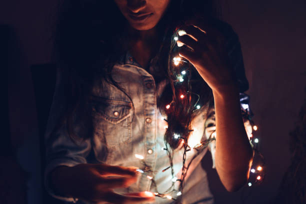istock Midsection of girl holding string lights in her hand 1053441278