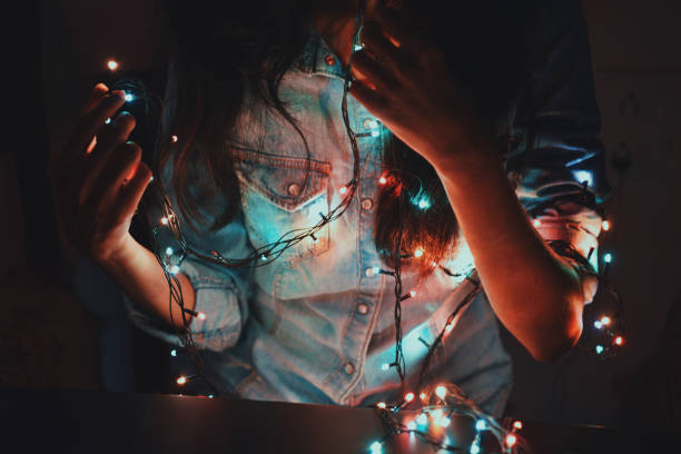istock Midsection of girl holding string lights in her hand 1053443668