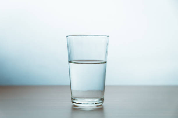 istock Glass Of Water On Table Against Wall 1053449138