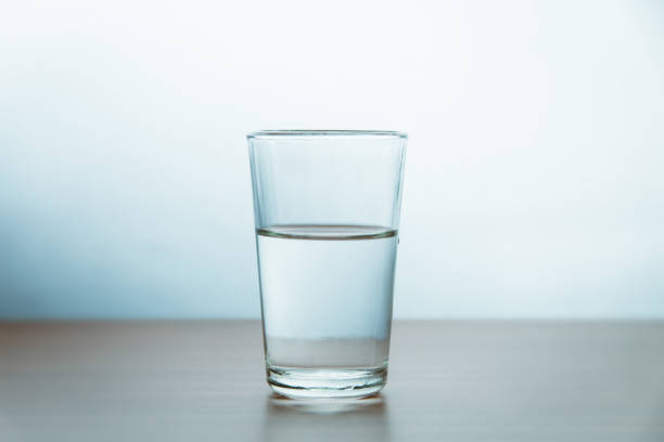 copo de água na mesa contra parede - glass of water - fotografias e filmes do acervo