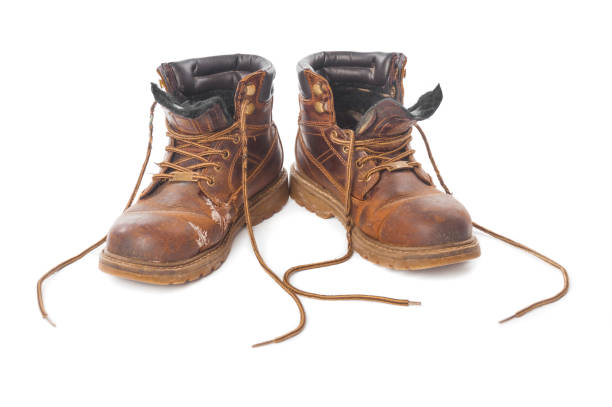 istock Pair of dirty brown boots isolated on white background 1053455160