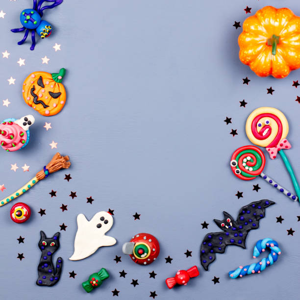 istock Halloween background with decorations. Black cat, bats, witches hat and broomstick with orange pumpkins. Top view 1053458366