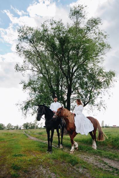 istock Couple Riding Horses On Field 1053460360