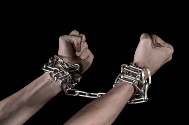 istock Hands tied chain, kidnapping, dependence, loneliness, social problem, halloween theme, killer, crazy, freedom black background 1053461048
