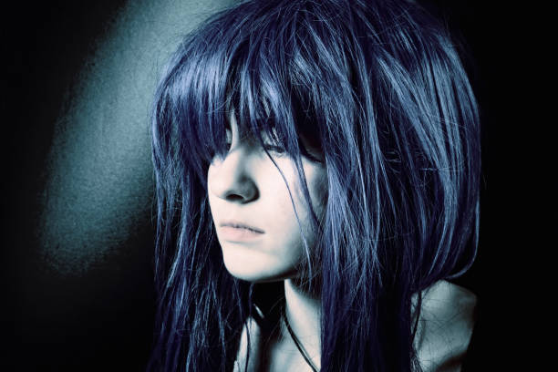 Dark woman portrait side view Portrait of a young woman with blue long hair, close-up. black hair emo girl stock pictures, royalty-free photos & images