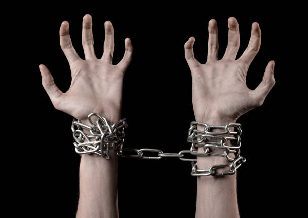 istock Hands tied chain, kidnapping, dependence, loneliness, social problem, halloween theme, killer, crazy, freedom black background 1053461982