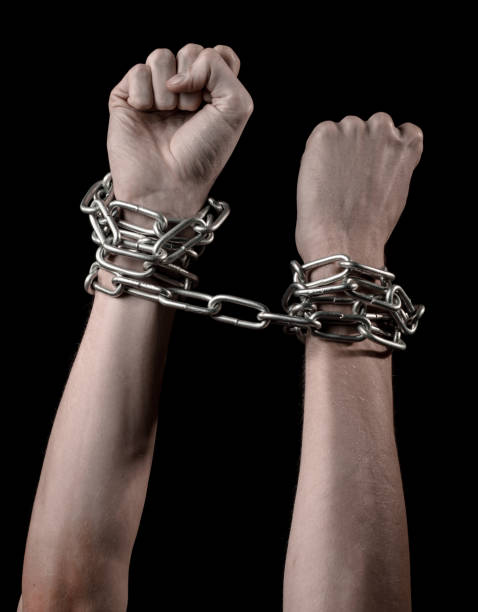 istock Hands tied chain, kidnapping, dependence, loneliness, social problem, halloween theme, killer, crazy, freedom black background 1053462078
