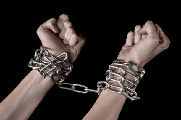 istock Hands tied chain, kidnapping, dependence, loneliness, social problem, halloween theme, killer, crazy, freedom black background 1053462096
