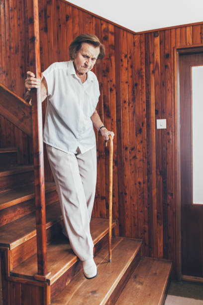 istock Elderly woman at home using a cane to get down the stairs 1053462232