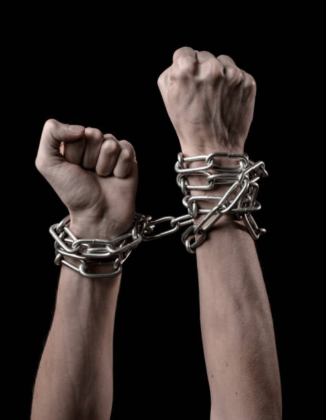 istock Hands tied chain, kidnapping, dependence, loneliness, social problem, halloween theme, killer, crazy, freedom black background 1053462236