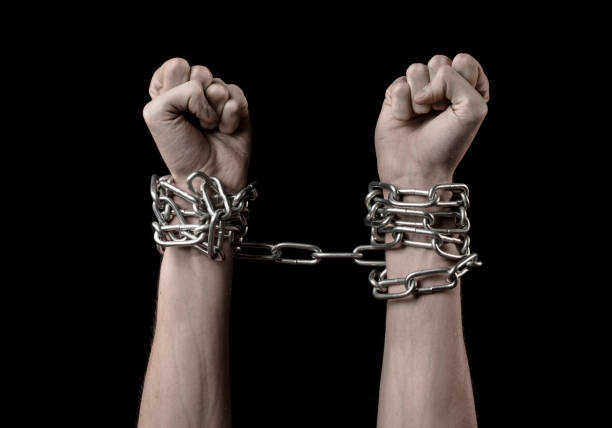 istock Hands tied chain, kidnapping, dependence, loneliness, social problem, halloween theme, killer, crazy, freedom black background 1053462566