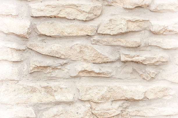 istock Texture, background, pattern. An old cement stone wall as vintage cracked, worn and worn out creative poster design. Cracks, scrapes, peeling old paint and plaster on the background of old cement wall 1053470382