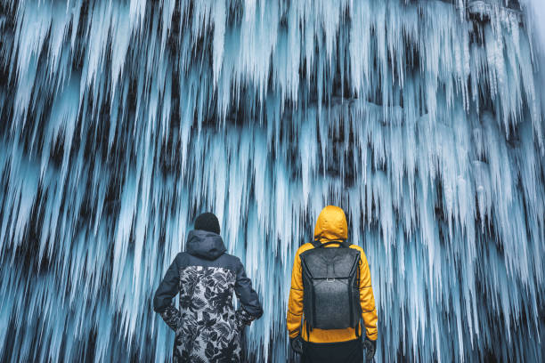 Couple Admiring The Frozen Waterfall