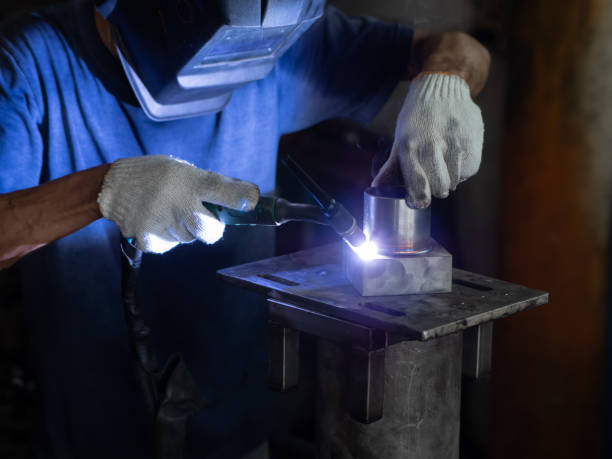 istock Men's hands with argon welding machine.  repair pipe stainless argon welding industrial construction 1053477586