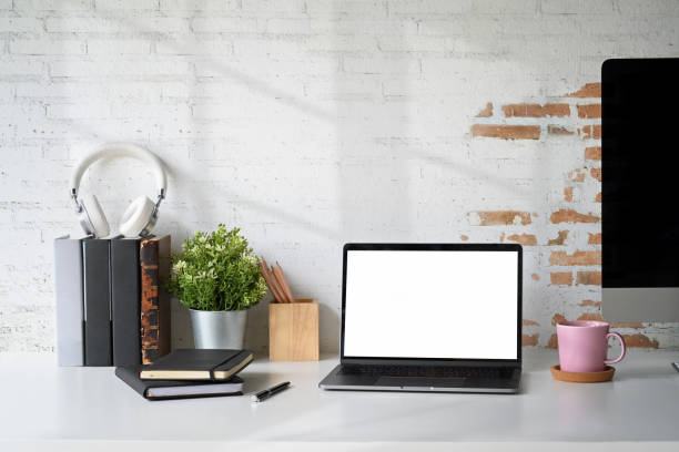 istock Loft workplace with mockup blank screen laptop and office supplies. 1053478442
