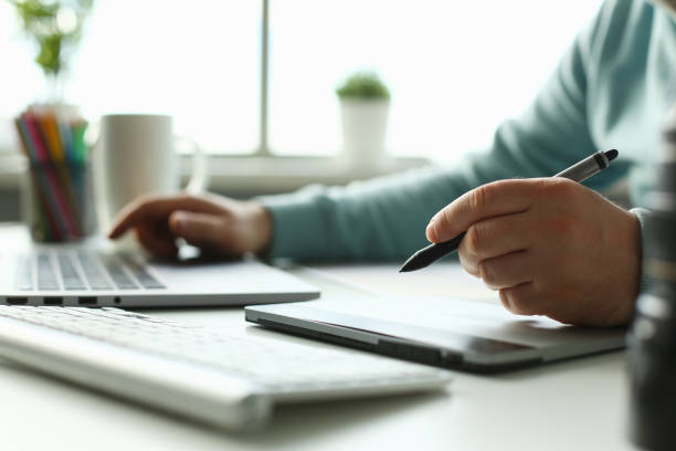 istock A young designer holds a pen from a tablet in his 1053479126