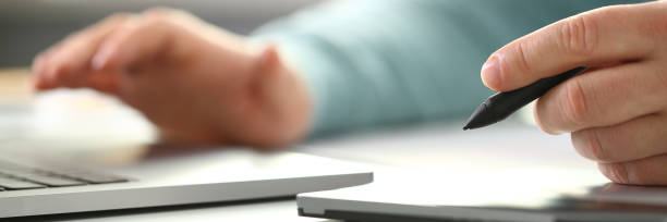 istock A young designer holds a pen from a tablet in his 1053479576