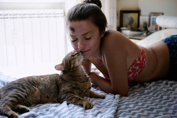 istock Woman Lying With Cat On Bed At Home 1053479958