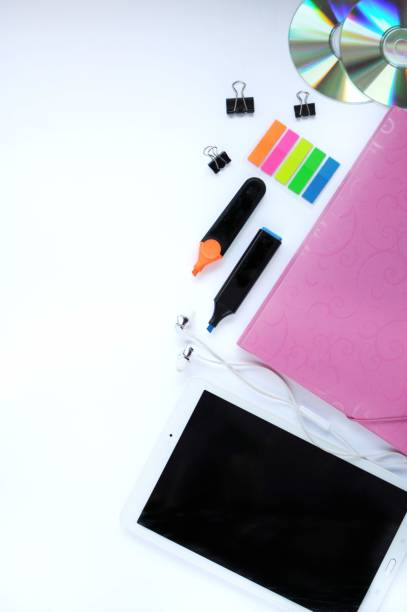 istock Study stuff. Education background. Stationery. Aspects of education. Stickers, tablet, markers, cd-discs, folder, headphones, clips on the table. 1053480288