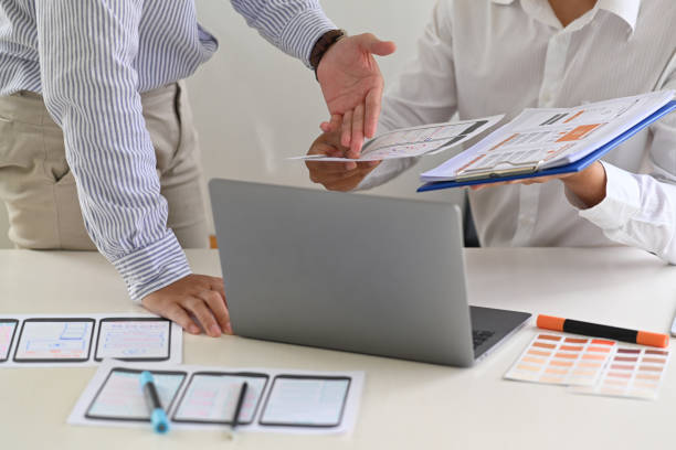 istock Two Asian Designer colleagues  drawing website UX UI app development with mockup layout mobile phone 1053483038
