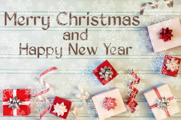 istock On a light blue background, small gift boxes with bows, decorative ribbons, Christmas composition. Next to the inscription Merry Christmas and Happy New Year. Lots of snowflakes in blur. Photo with a festive mood. 1053494110