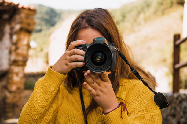 istock Young woman taking a picture with a DSLR camera 1053494680