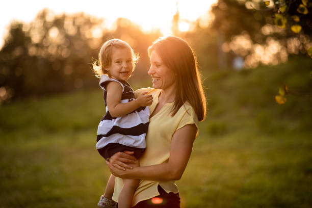 istock Mother holding her baby in the park 1053496574