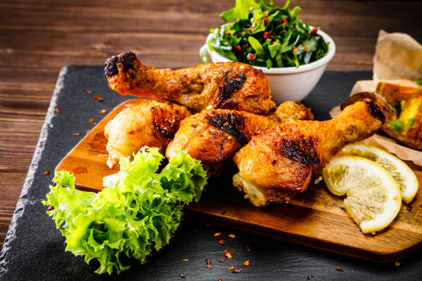 istock Fried chicken drumsticks with baked potatoes and vegetables 1053501618