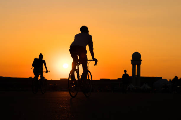 istock silhouette of young man riding racing bicycle with sunset sky background 1053501808