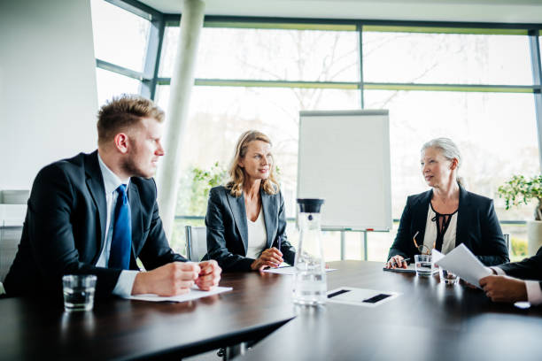 Business Meeting Between Shareholders and Managers A business meeting between shareholders and managers in a modern office conference room. shareholder photos stock pictures, royalty-free photos & images
