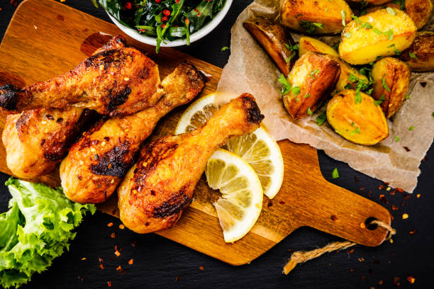 istock Fried chicken drumsticks with baked potatoes and vegetables 1053502950