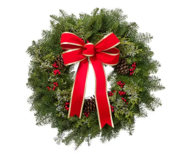 Christmas real pine wreath arrangement with a big red bow isolated on white