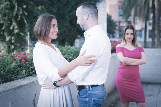 cheerful couple are talking and woman is envying them - disaffection imagens e fotografias de stock