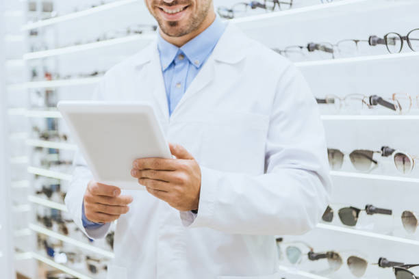 istock cropped view of optometrist in white coat using digital tablet in optica 1053516246