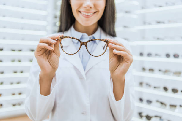 istock cropped view of smiling professional optometrist holding glasses 1053516472