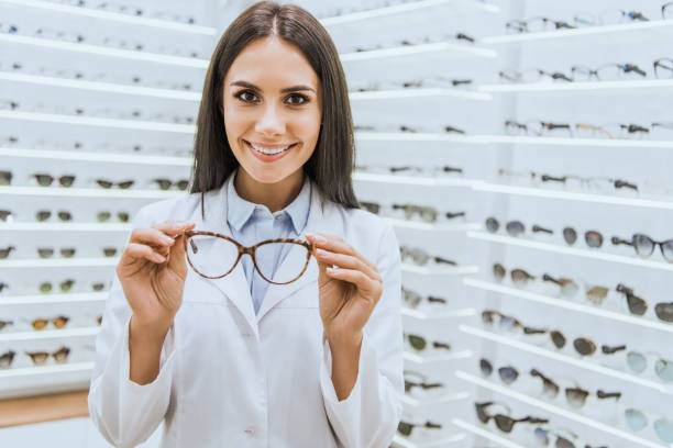 istock professional smiling optometrist holding glasses in ophthalmic shop 1053516532