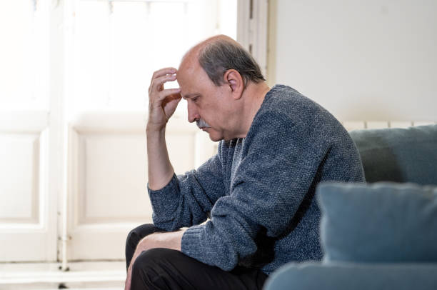 istock Senior old man feeling desperate sad looking worried depressed thoughtful and lonely on couch at home in Aging Mental health Personal problems and Life style concept. 1053516640