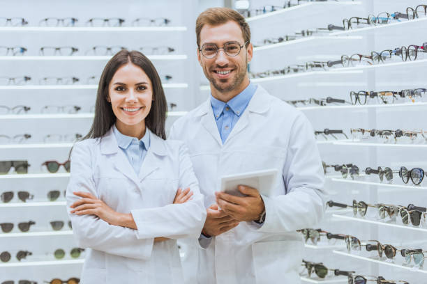 istock two oculists with digital tablet looking at camera in optica 1053516664
