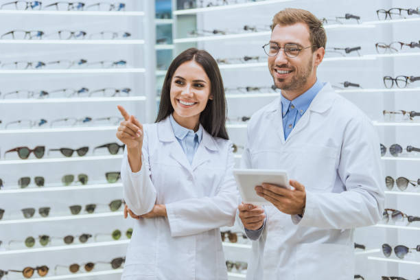 istock smiling optometrists using digital tablet while female doctor pointing at eyeglasses in optica 1053516718