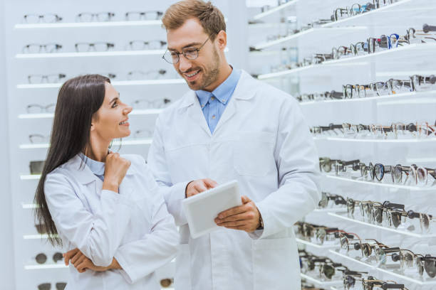 istock two optometrists using digital tablet and looking at each other in optica with glasses 1053517026