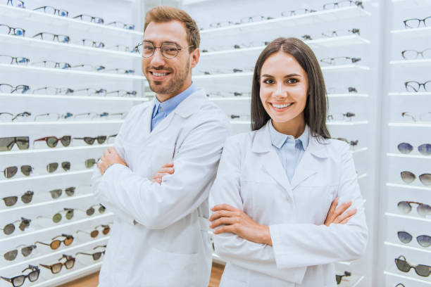 istock professional opticians in white coats standing with crossed arms in ophthalmology 1053517172